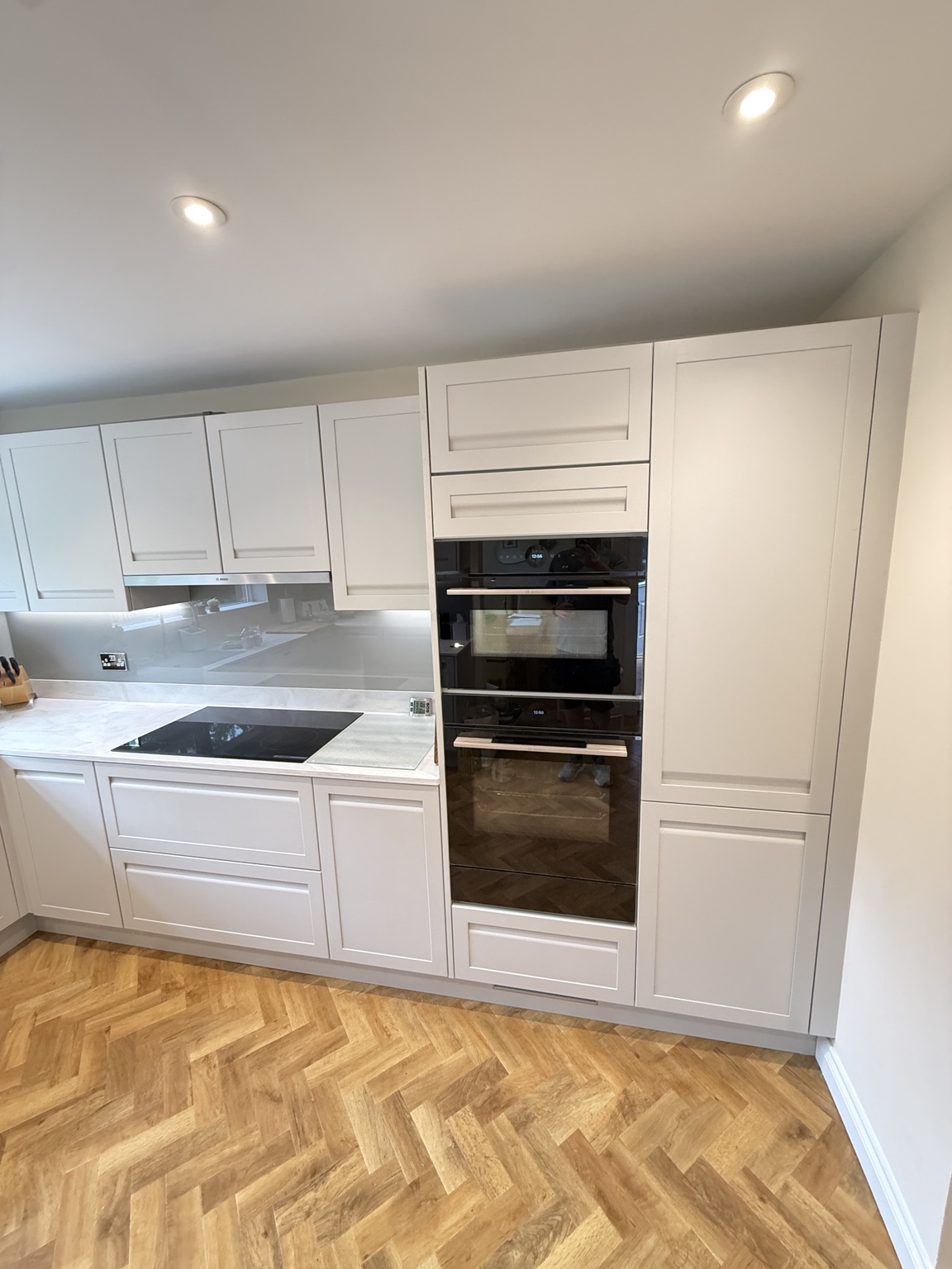 Precisely fitted oven housing and full-height Shaker kitchen cabinets