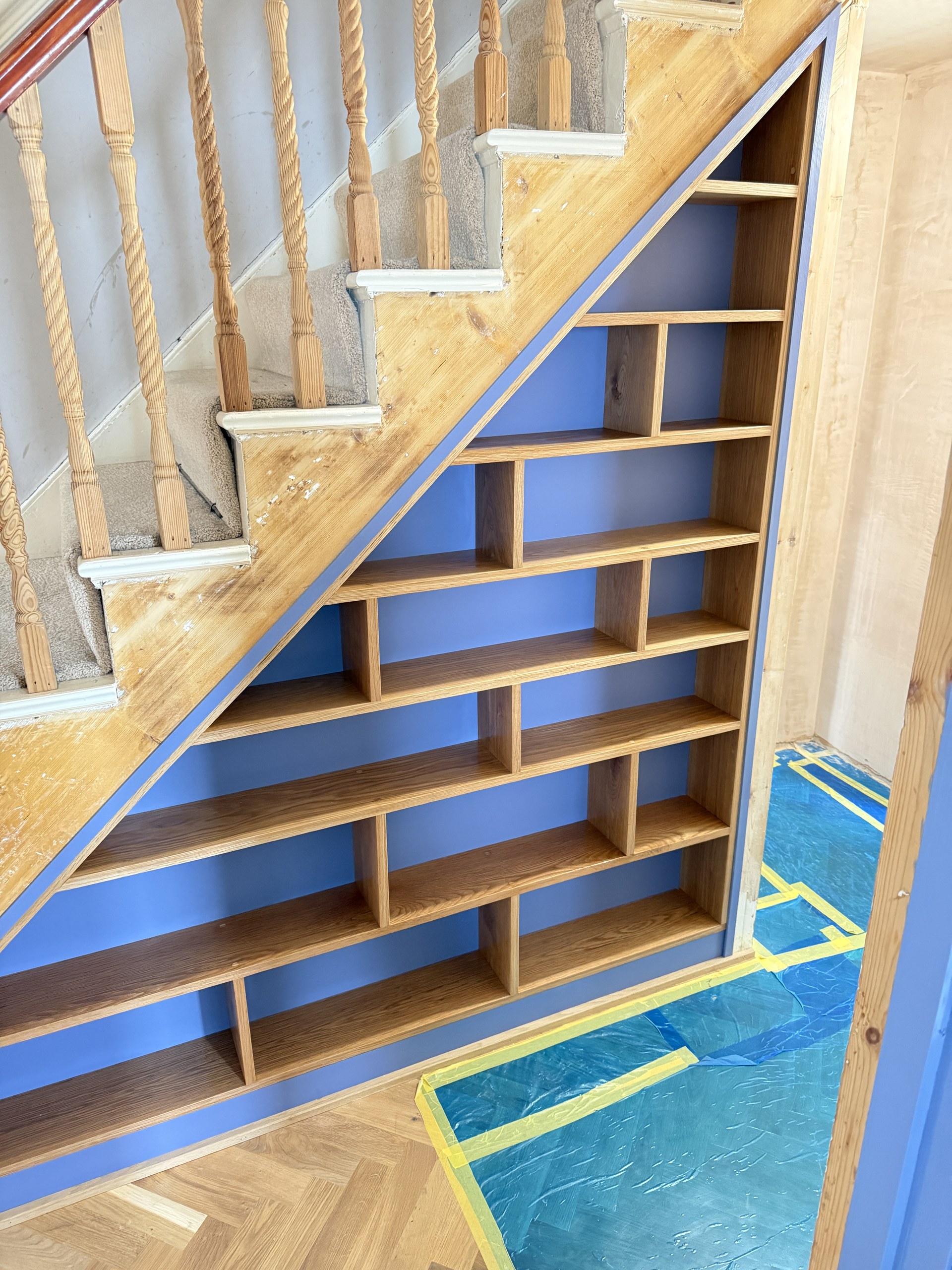 Closer view of the fitted under-stair shelving compartments and timber edging