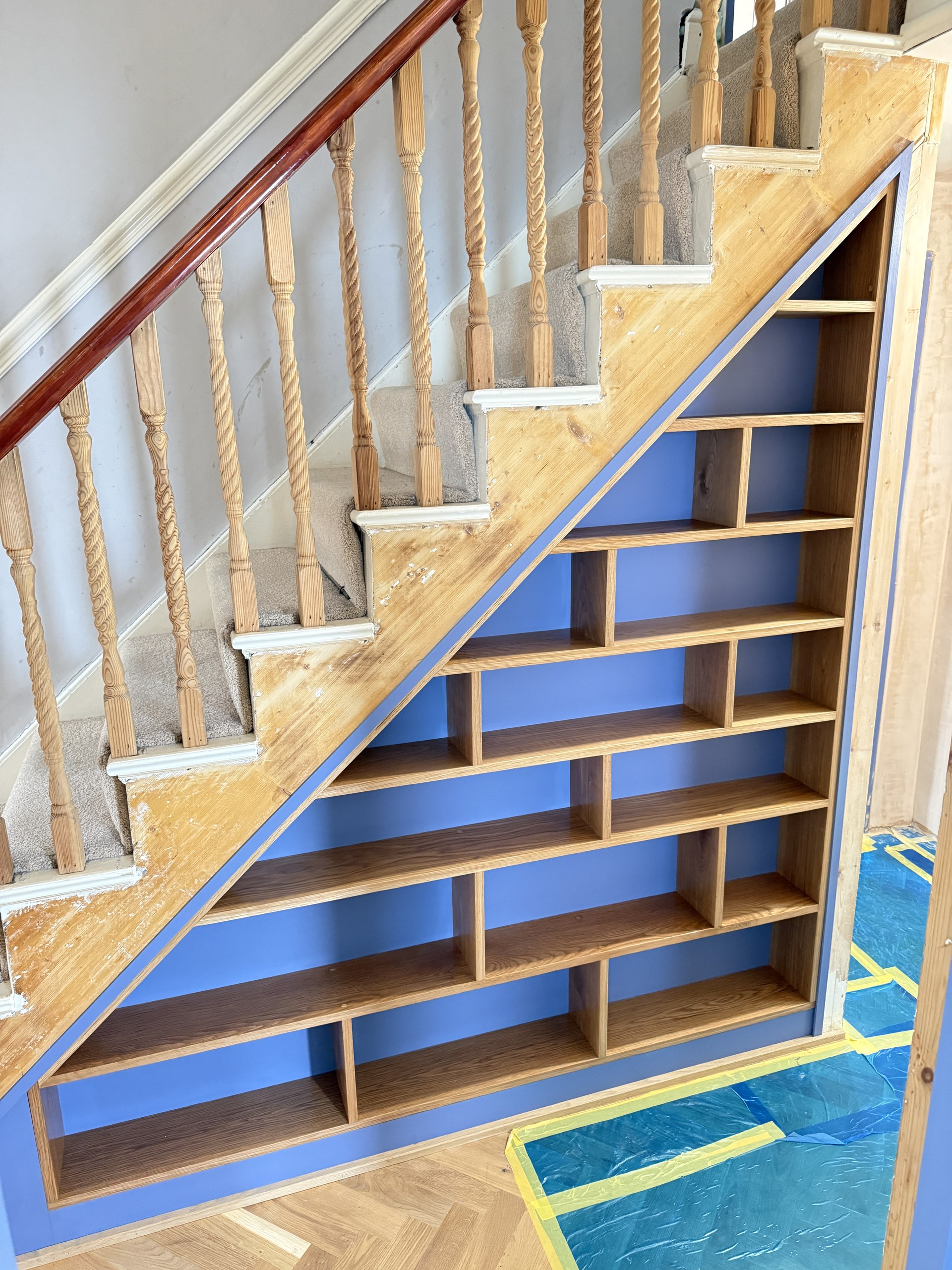 Completed blue built-in shelving fitted to the sloping space beneath a staircase in Worthing